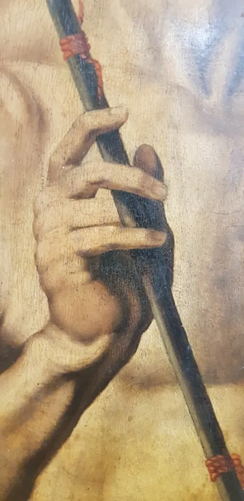 La main droite du Saint Sébastien serrant la flèche, son attribut principal, en lumière visible